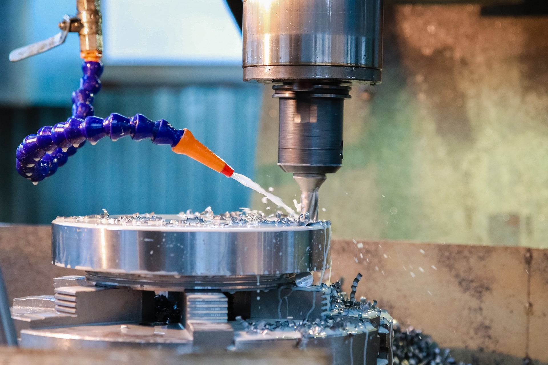 Maszyna CNC obrabiająca metal. Strumień chłodziwa smaruje narzędzie skrawające i usuwa wióry.