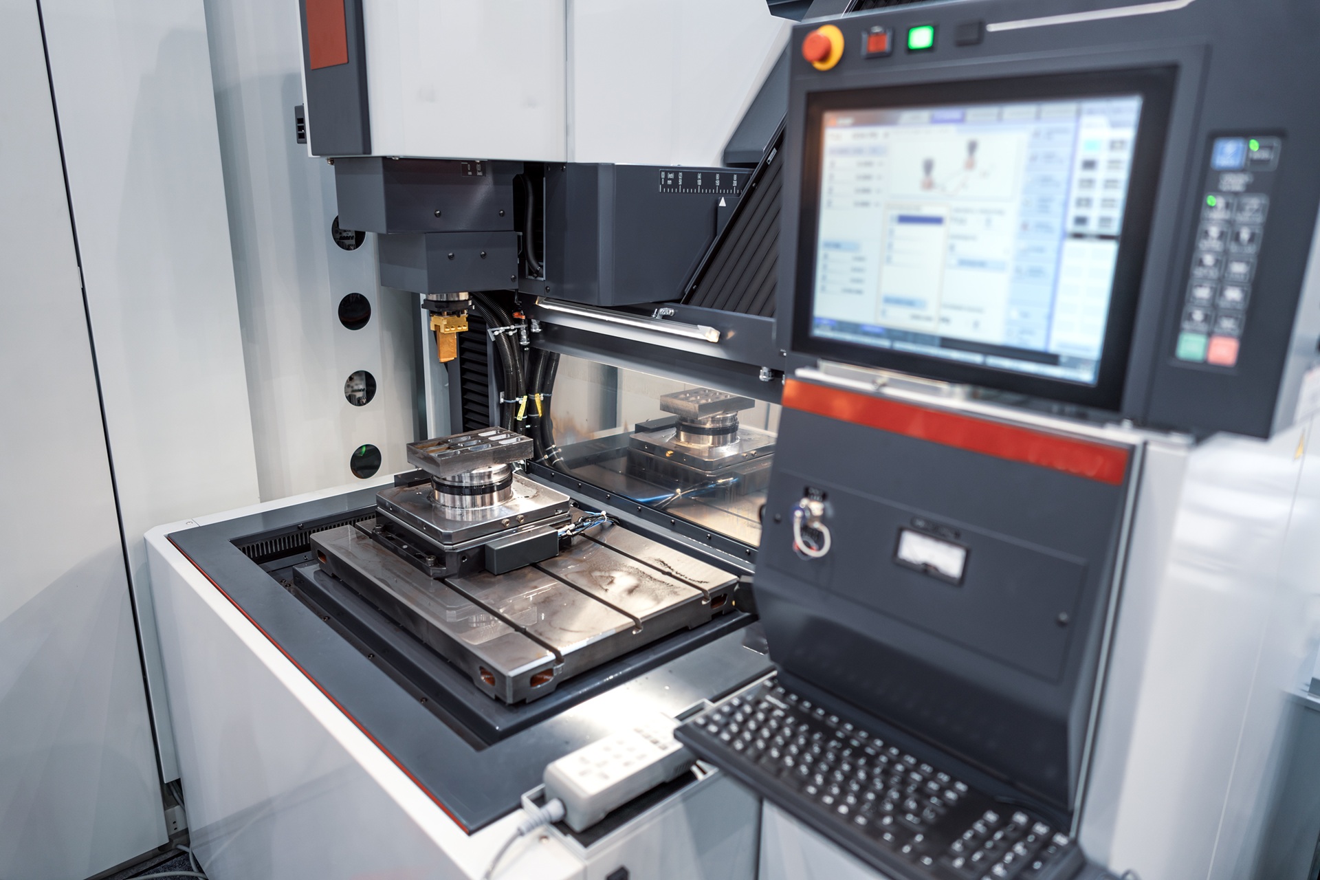 Wnętrze frezarki CNC obrazujące stabilny układ OUPN: sztywne oprzyrządowanie CNC mocujące detal oraz wrzeciono gotowe do precyzyjnej pracy.