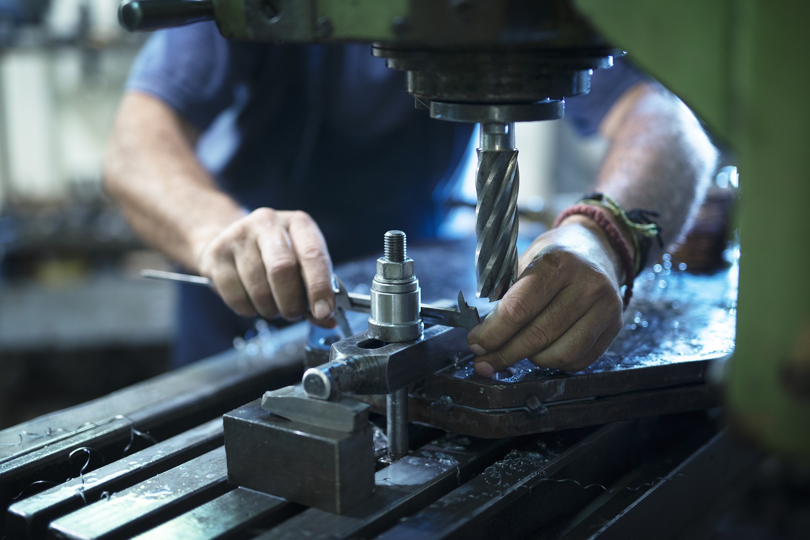 Pomiar metalowego element osadzonego na maszynie cnc za pomocą suwmiarki 